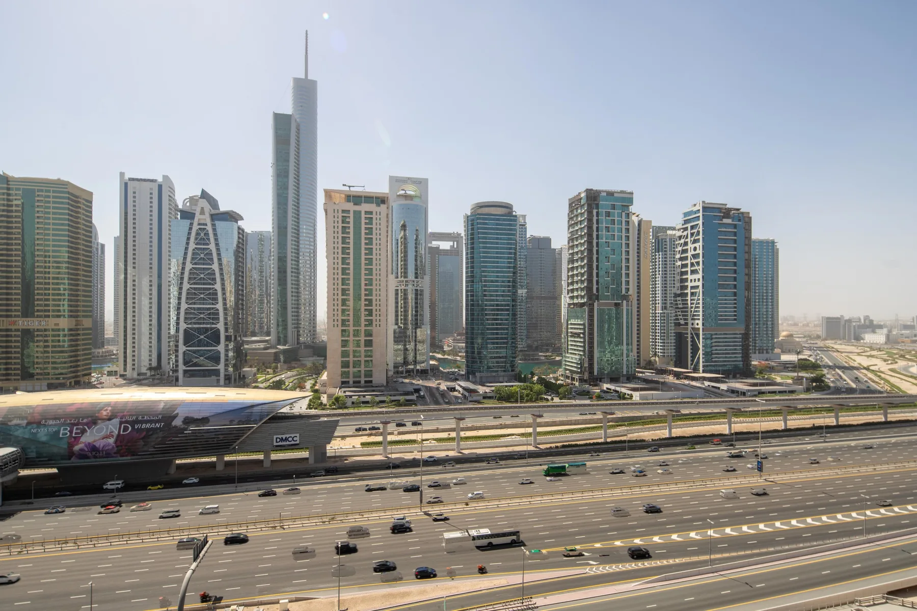 A city skyline of tall modern buildings rises above multilane roads.