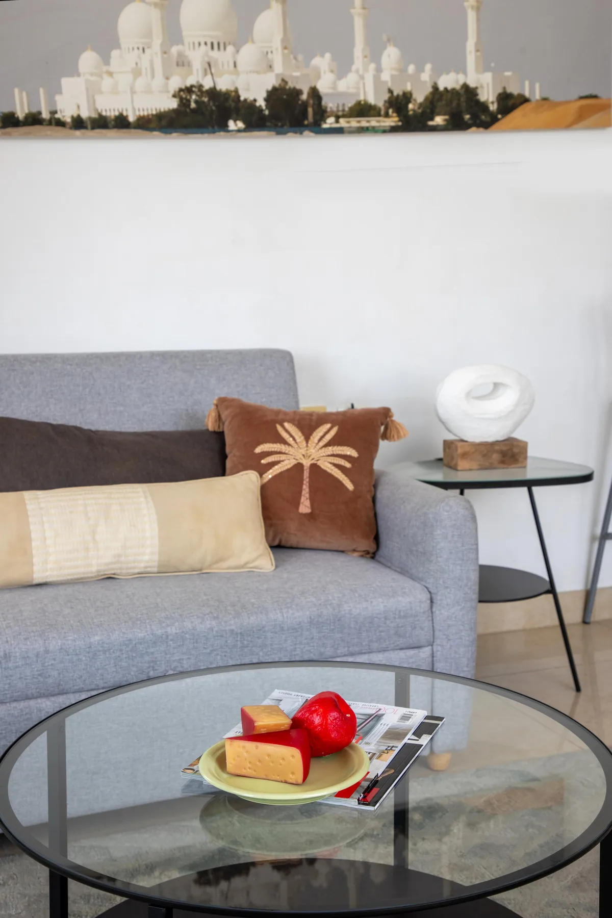 A living room seating area with a gray sofa and a glass coffee table.