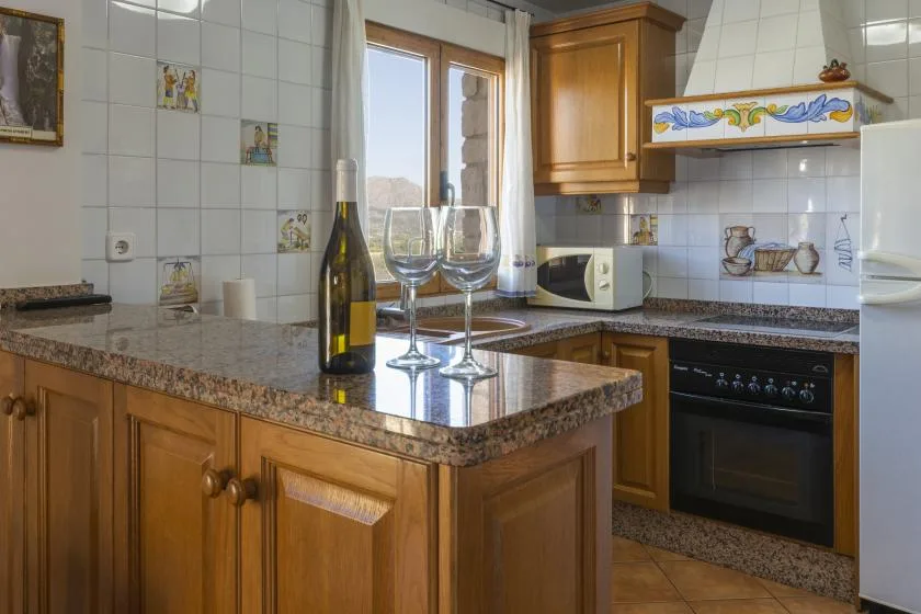 A kitchen with wooden cabinets, a tiled backsplash, and a central counter.
