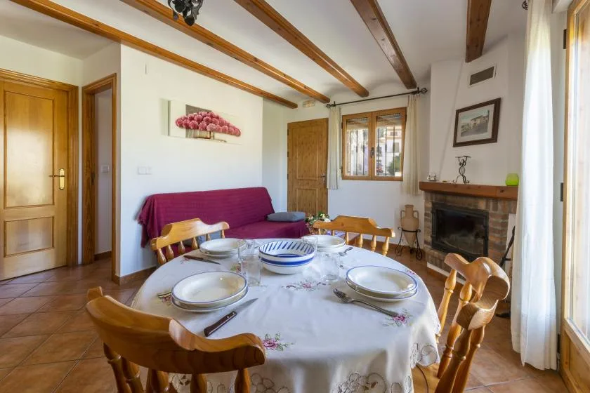 Comedor con una mesa puesta y una chimenea junto a la pared.