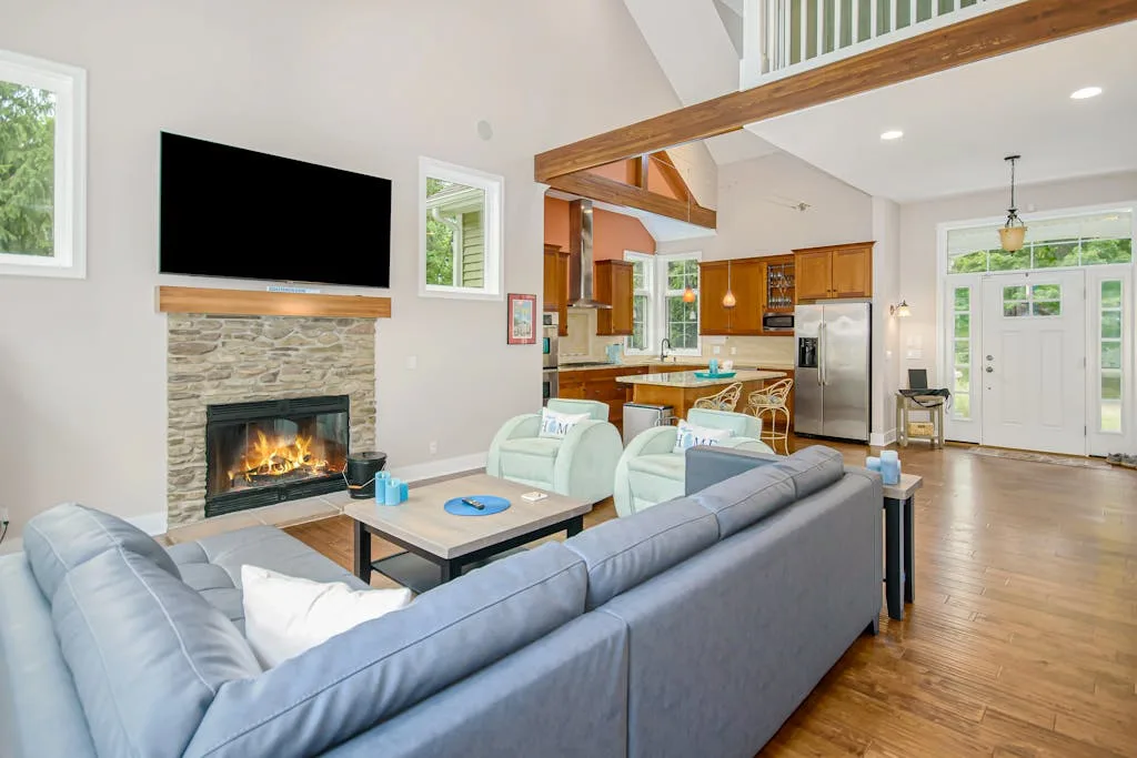 An open-plan living room and kitchen with a fireplace and seating.