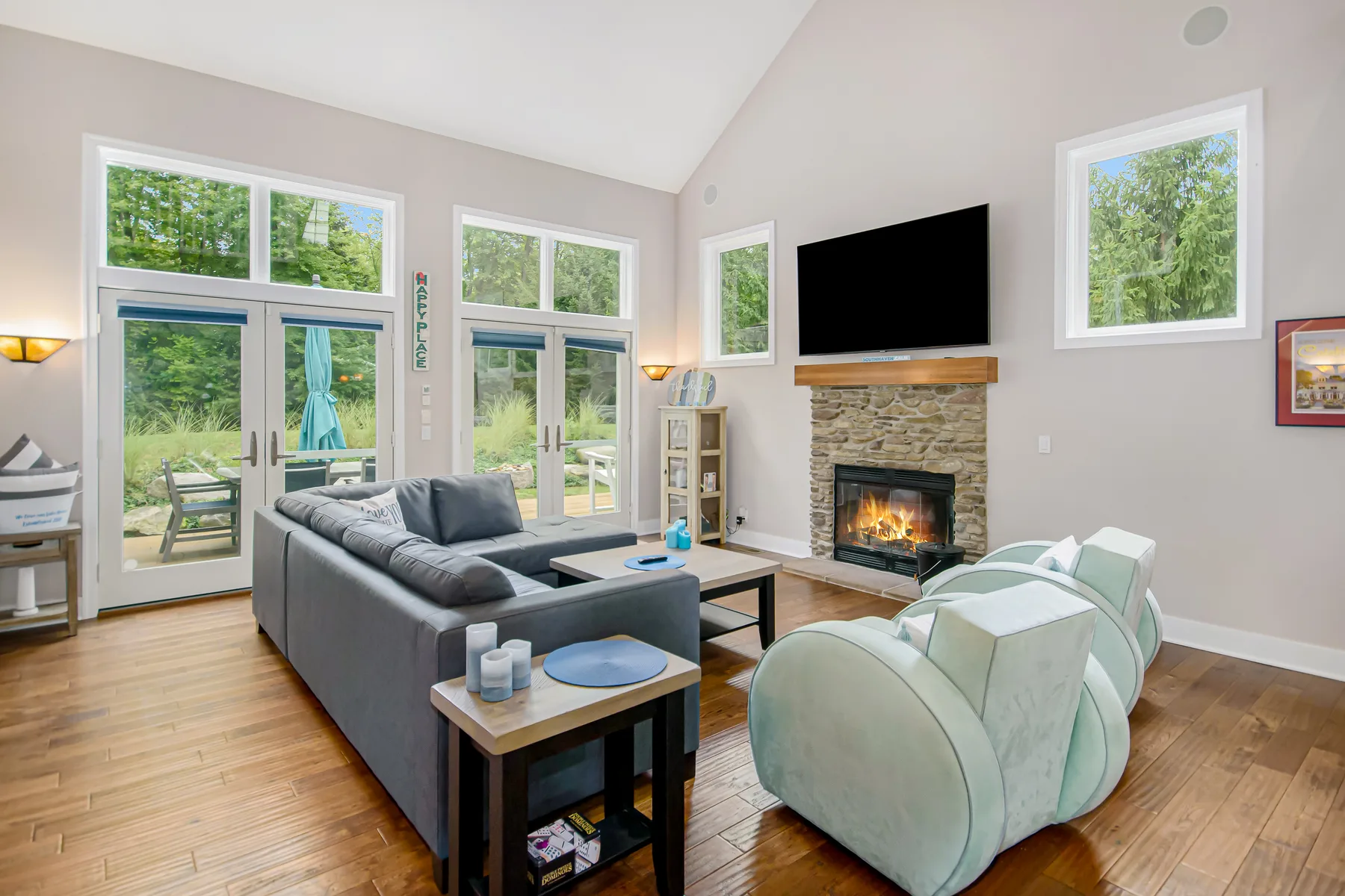 A living room with seating arranged around a fireplace and television.