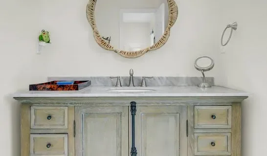 Un tocador de baño con lavabo, espejo y cajones.