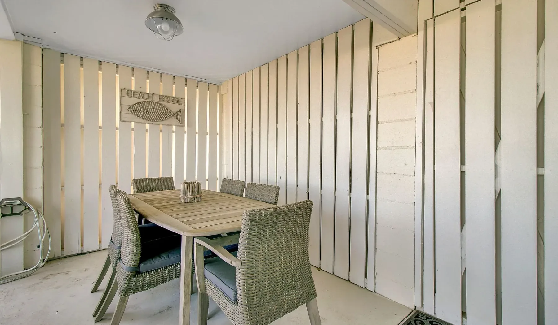 Un comedor cubierto con una mesa de madera y asientos tejidos.
