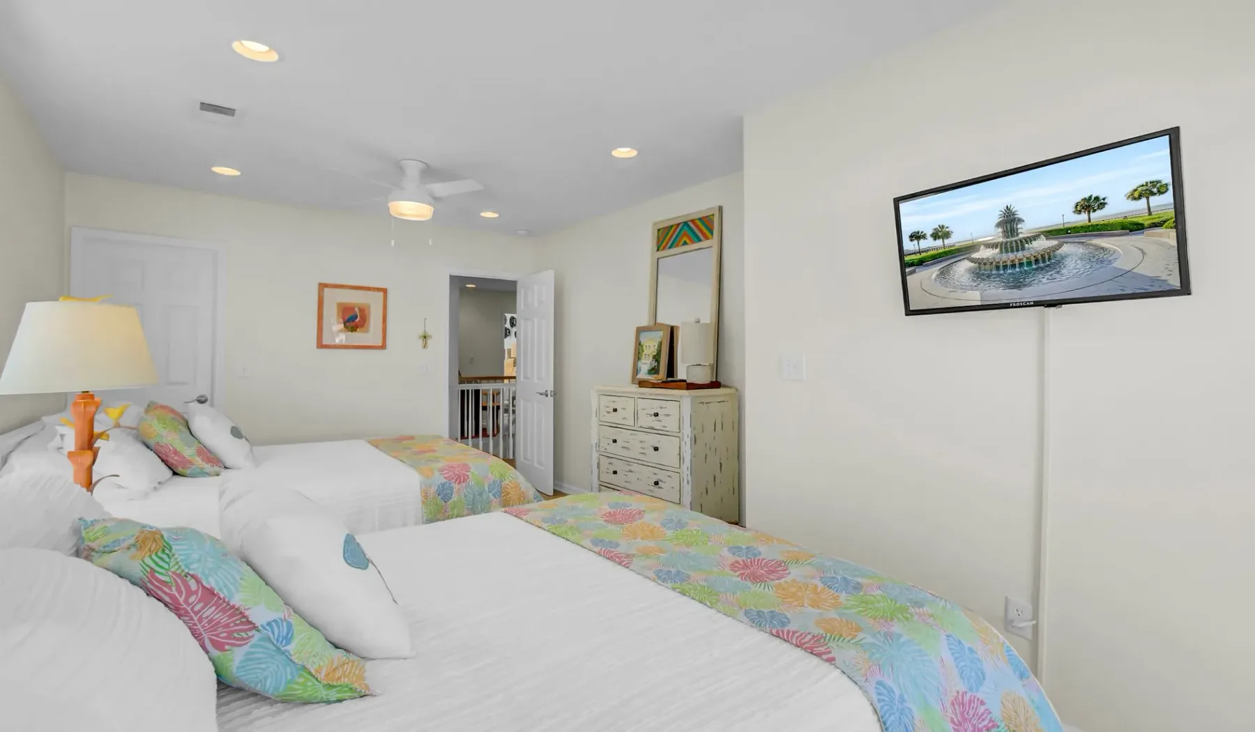 Un dormitorio con dos camas cubiertas con ropa de cama de estampados coloridos.
