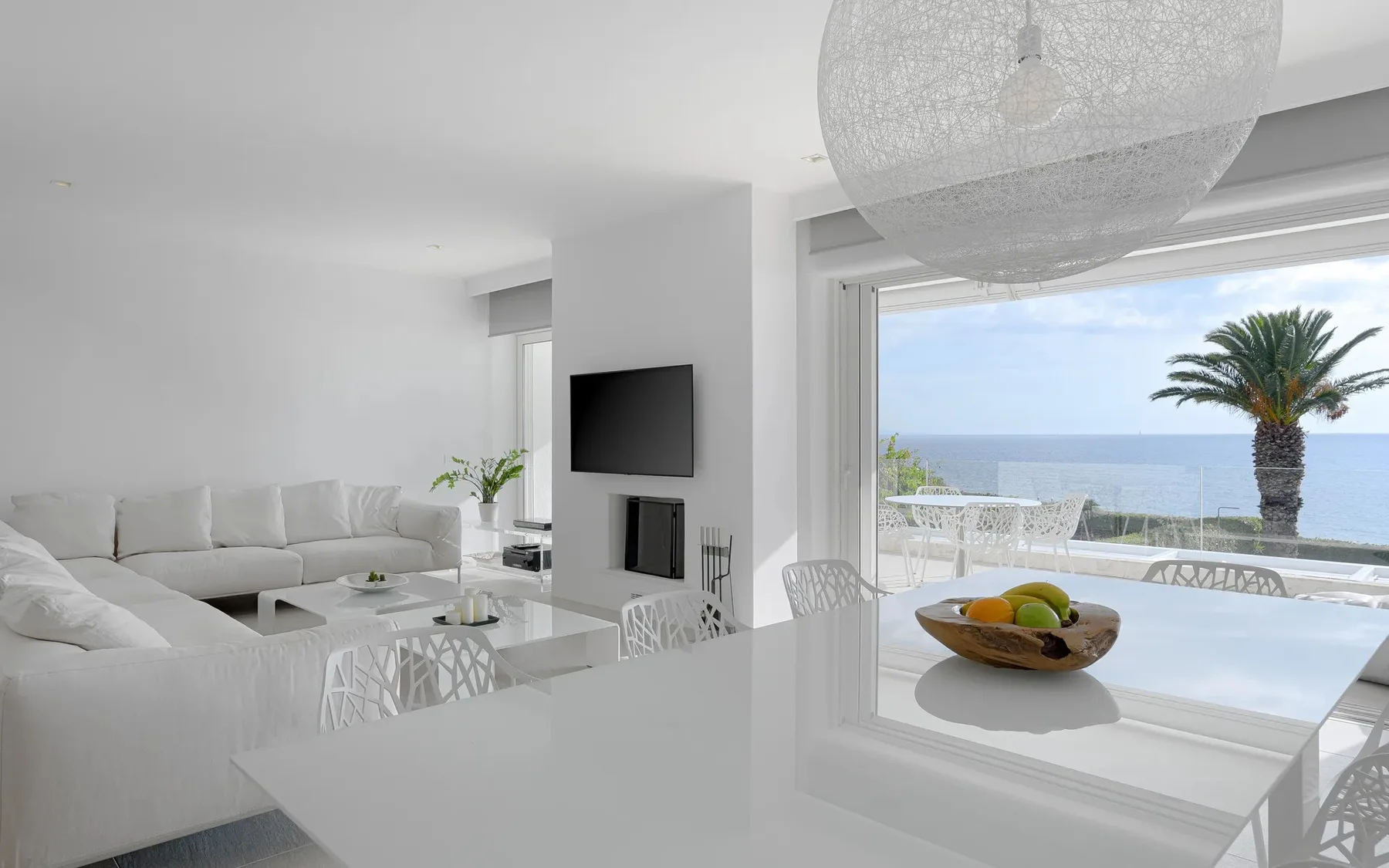 A bright living room opens onto a terrace with a sea view.