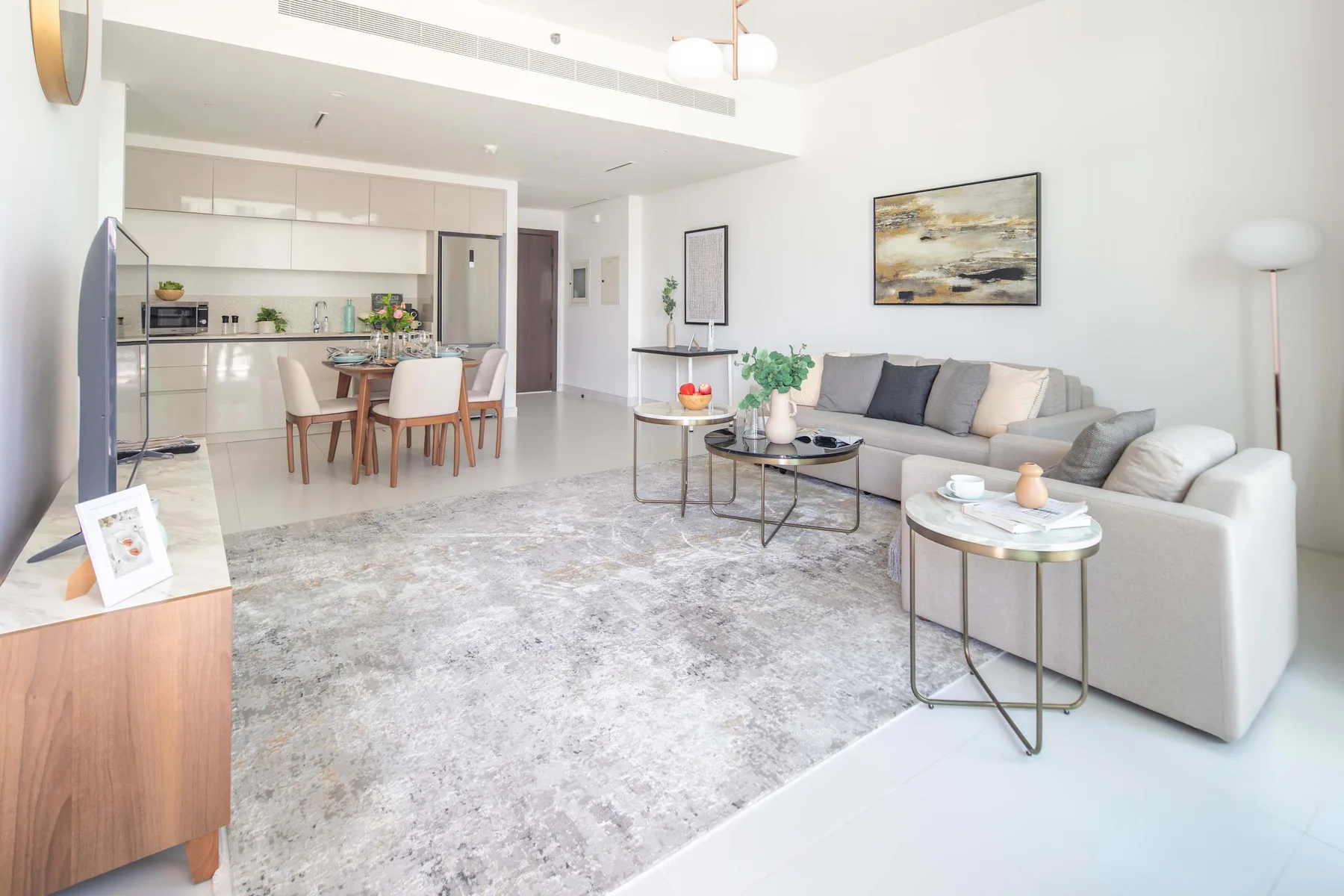 An open-plan living and dining area with a gray seating area and dining table.