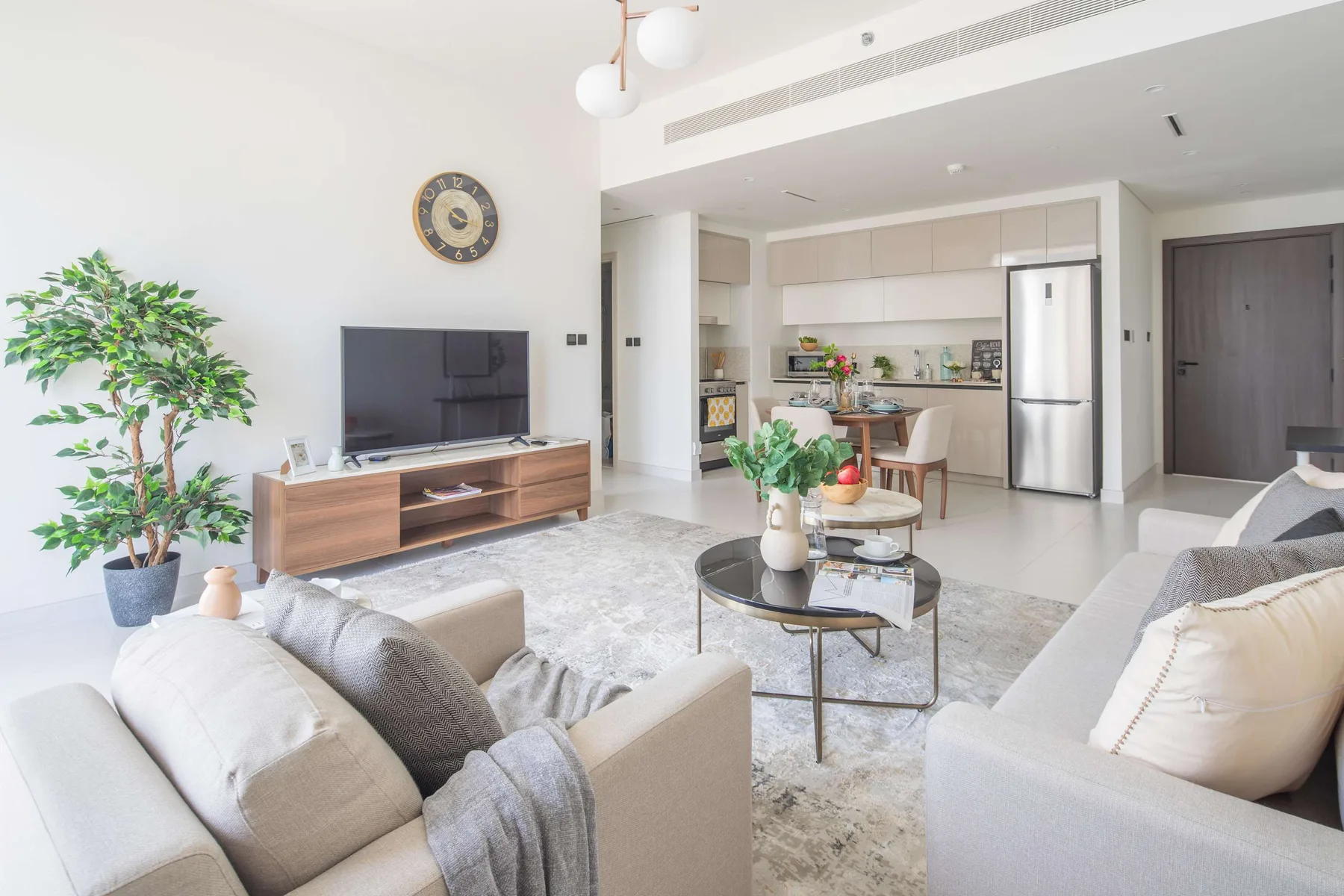A bright living room opens onto a dining area and kitchen.