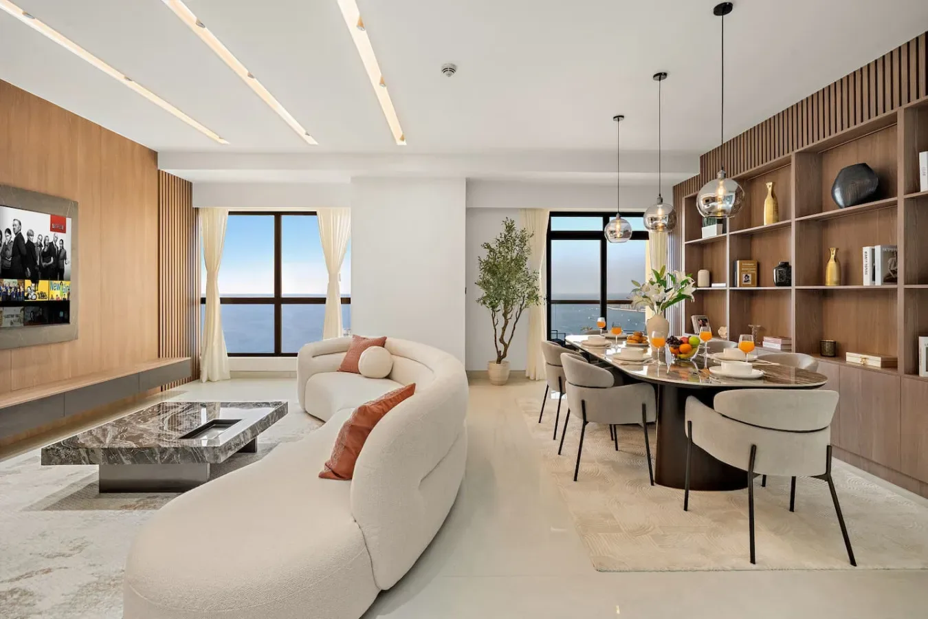 An open-plan living and dining area with large windows and built-in shelving.