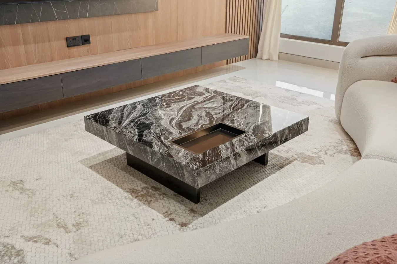 A living room with a patterned stone coffee table on a light rug.