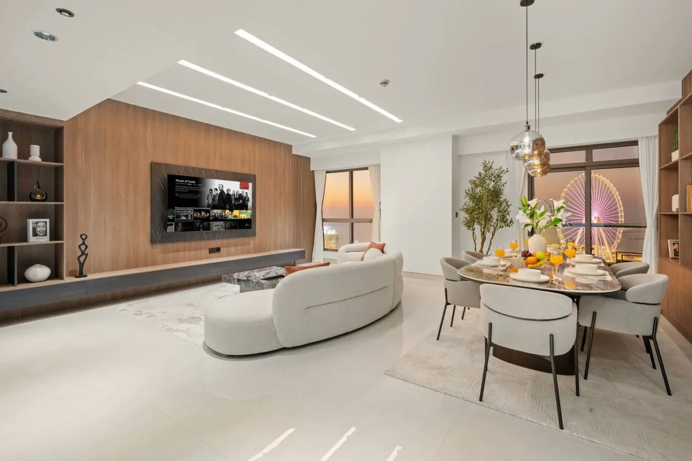 A bright open-plan living and dining area features a curved seating area and a set dining table.