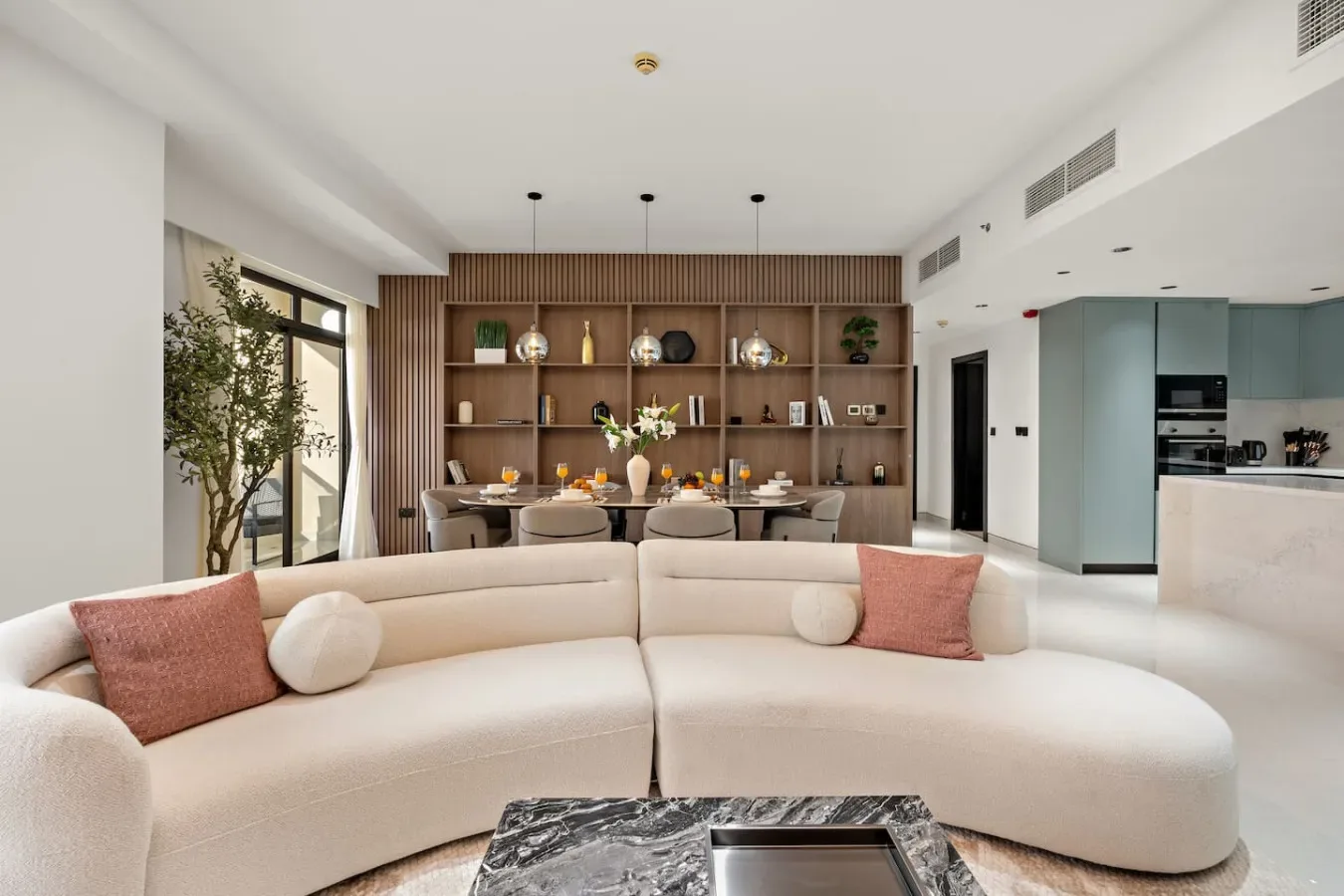 A bright living room with curved seating and a wooden display wall.
