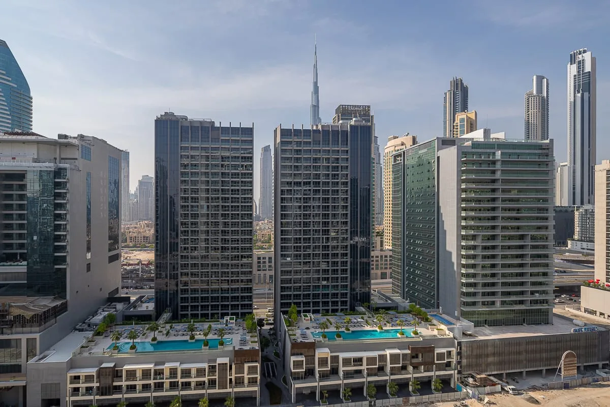 A city skyline of high-rise buildings, with rooftop pools in the foreground.