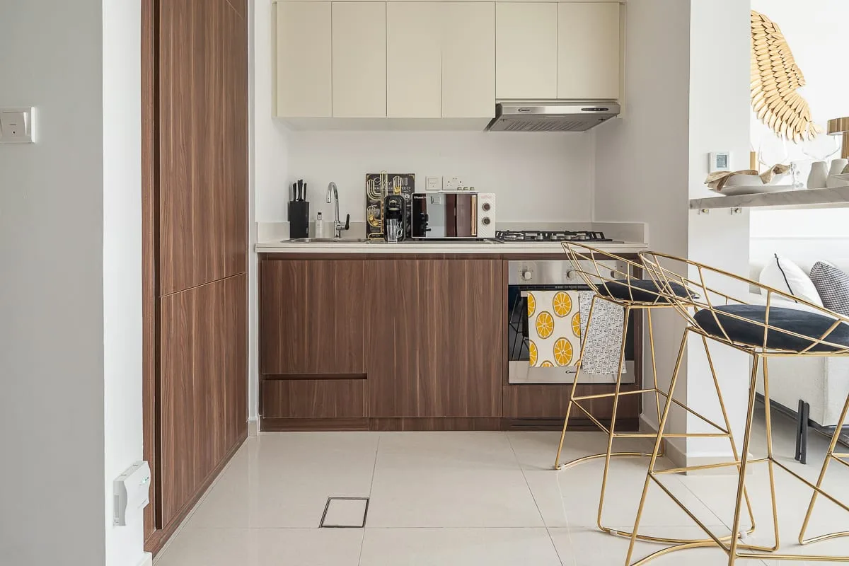 A modern kitchen with wood-toned cabinets and a counter beside bar seating.