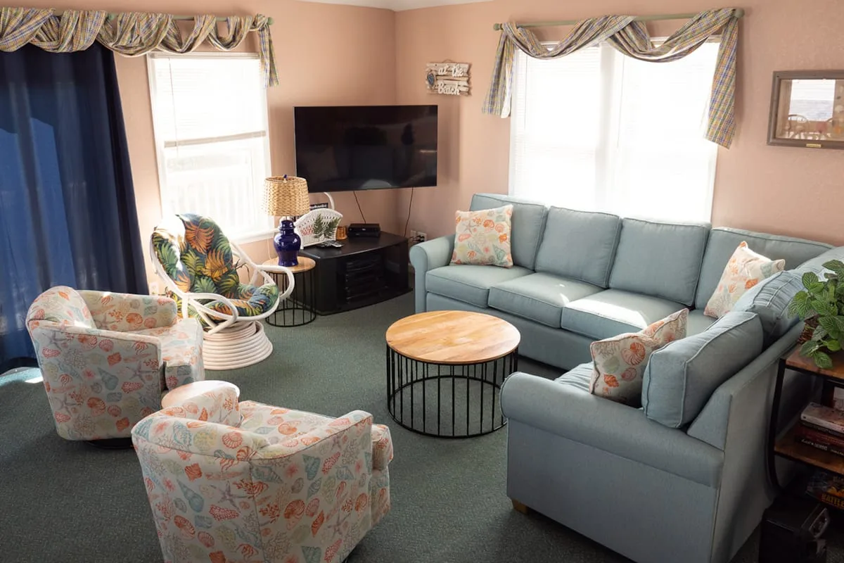 A living room with seating arranged around a coffee table and television.
