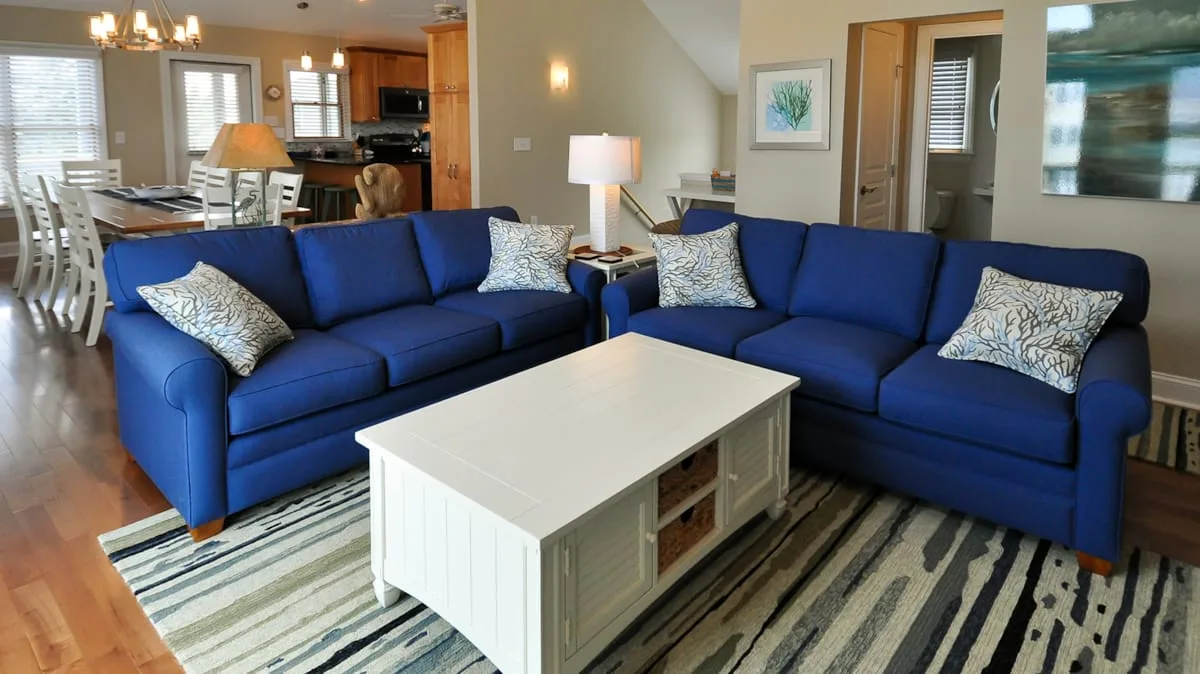 A living room with blue seating arranged around a white coffee table.