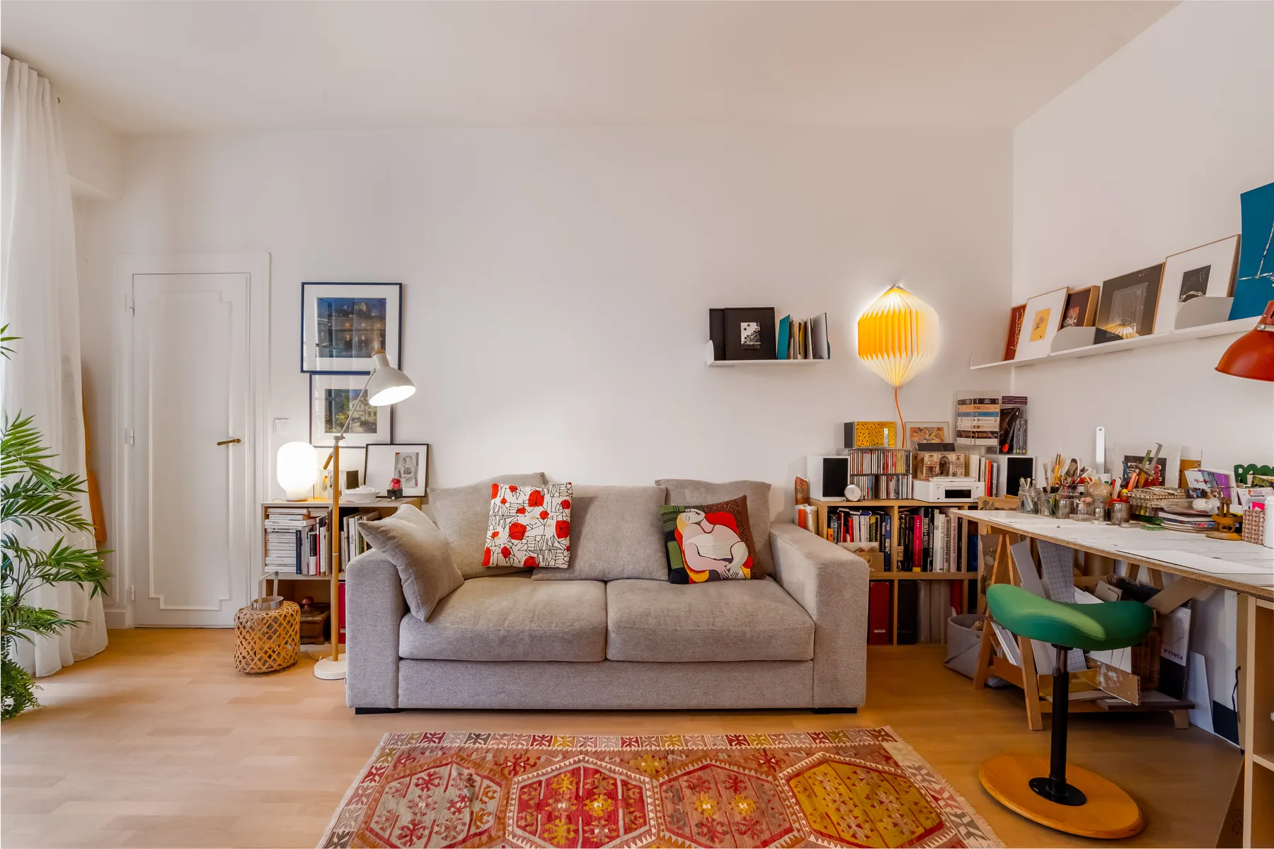 A living room with a sofa, bookshelves, and a patterned rug.