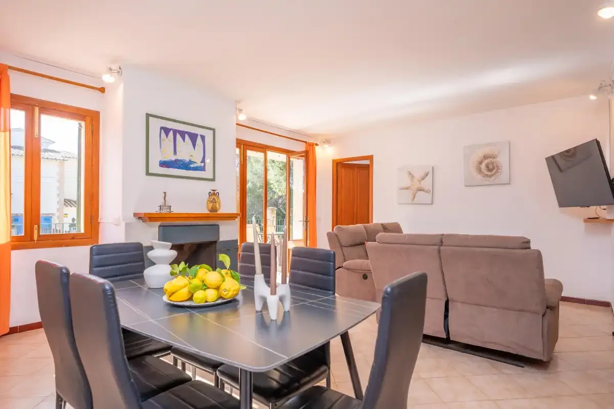 Sala de estar y comedor con mesa, asientos y una chimenea.