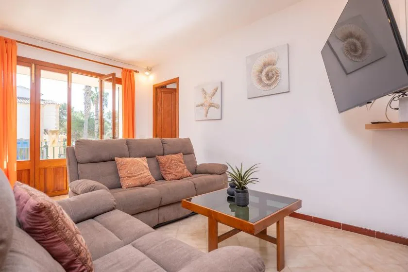 Una sala de estar con asientos, una mesa de centro y grandes ventanas.