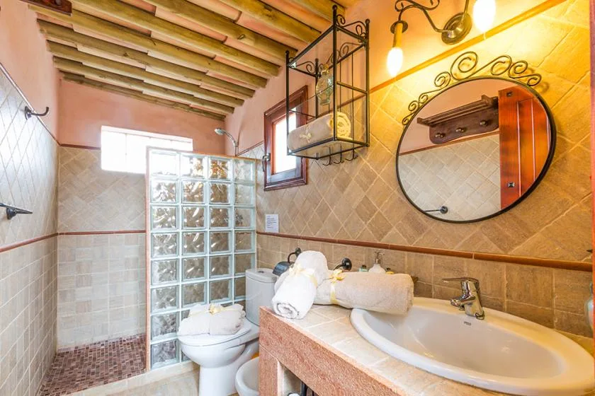 A tiled bathroom with a bathtub, sink, and glass-block shower partition.