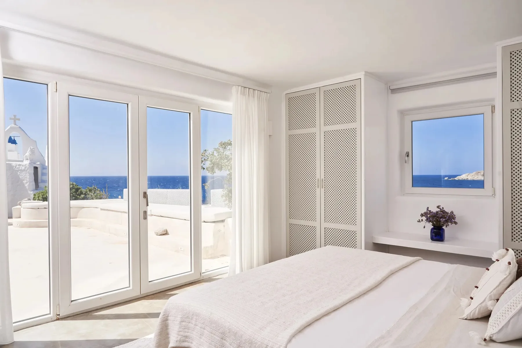 A bright bedroom opens onto a terrace with views of the sea.