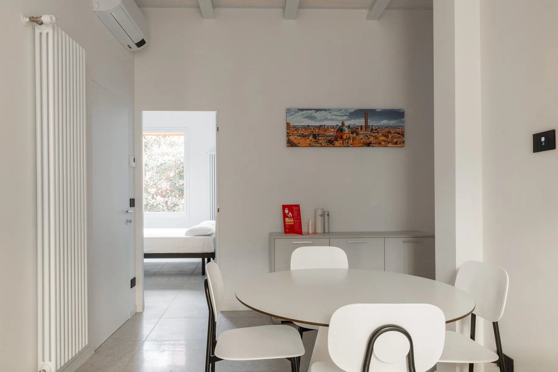 Un comedor luminoso con una mesa y sillas junto a una puerta abierta.