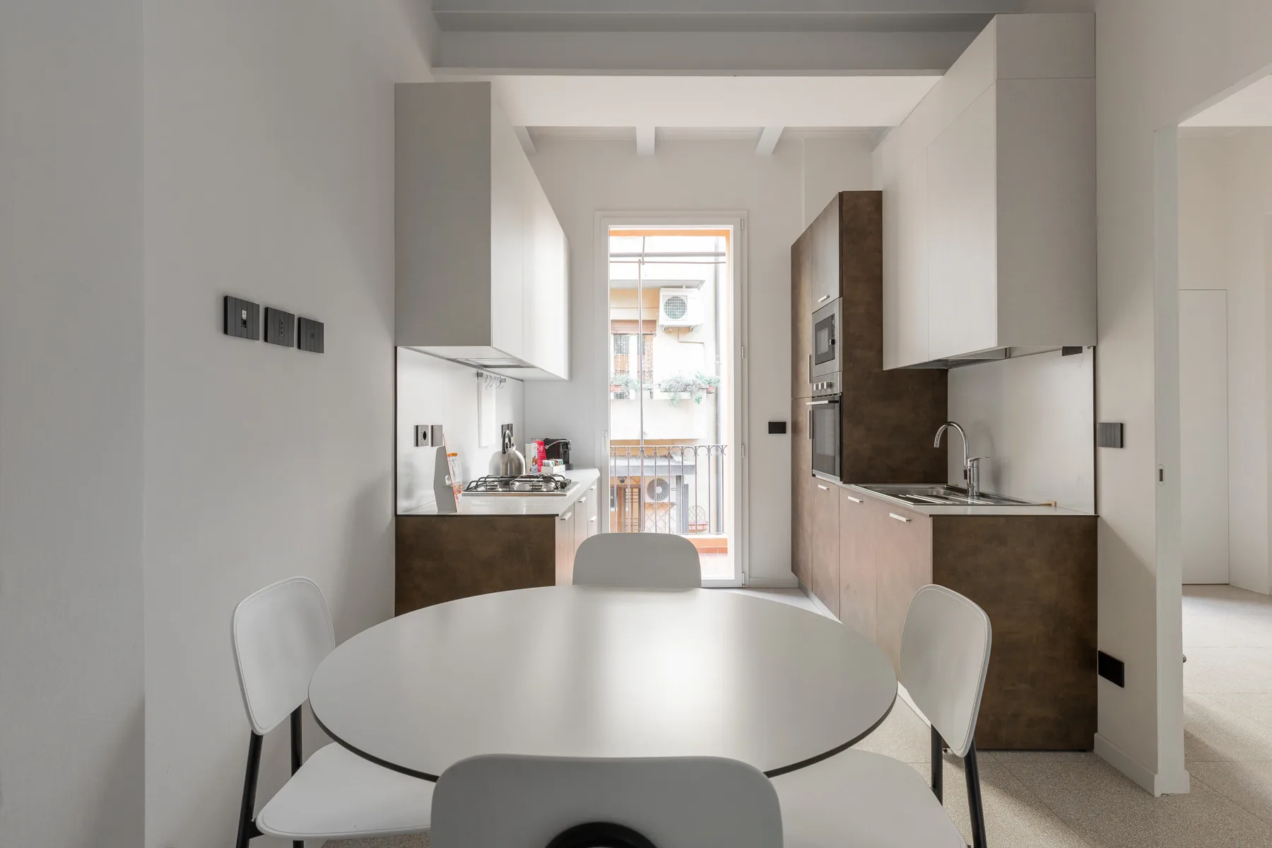 Una cocina luminosa con comedor, una mesa redonda y asientos alrededor.