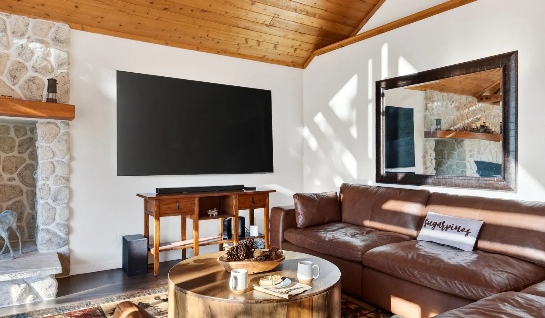 A living room with a brown sectional, television, and wooden coffee table.
