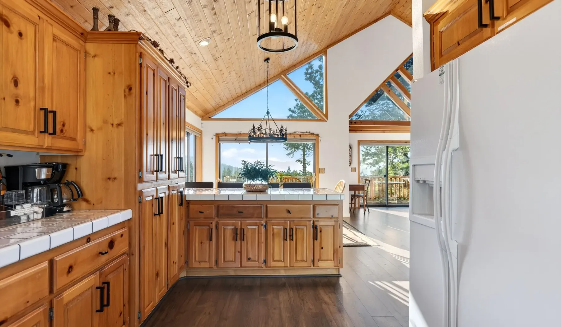 A wood-paneled kitchen with a central island and large windows.