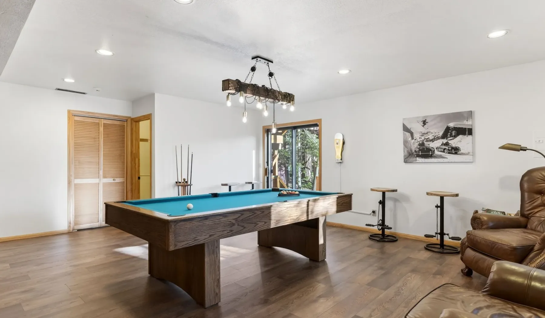 A game room with a pool table and seating.