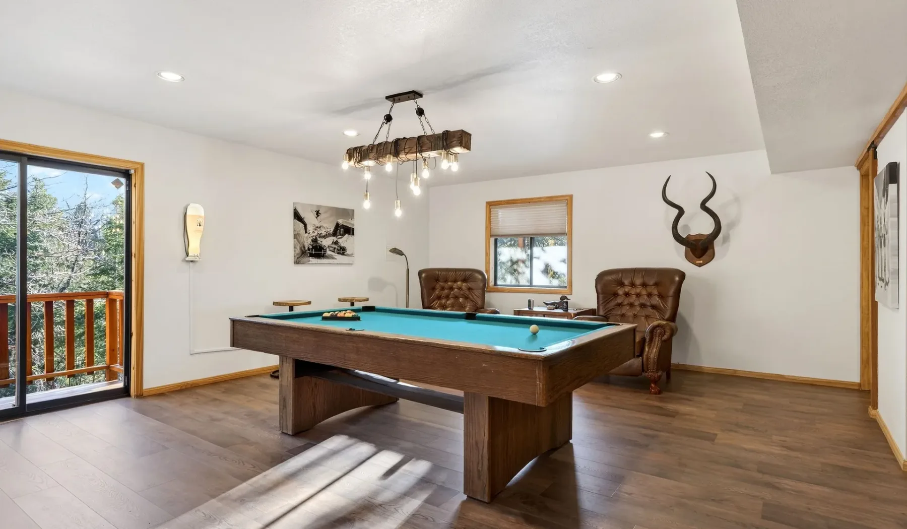 A game room with a pool table and seating.