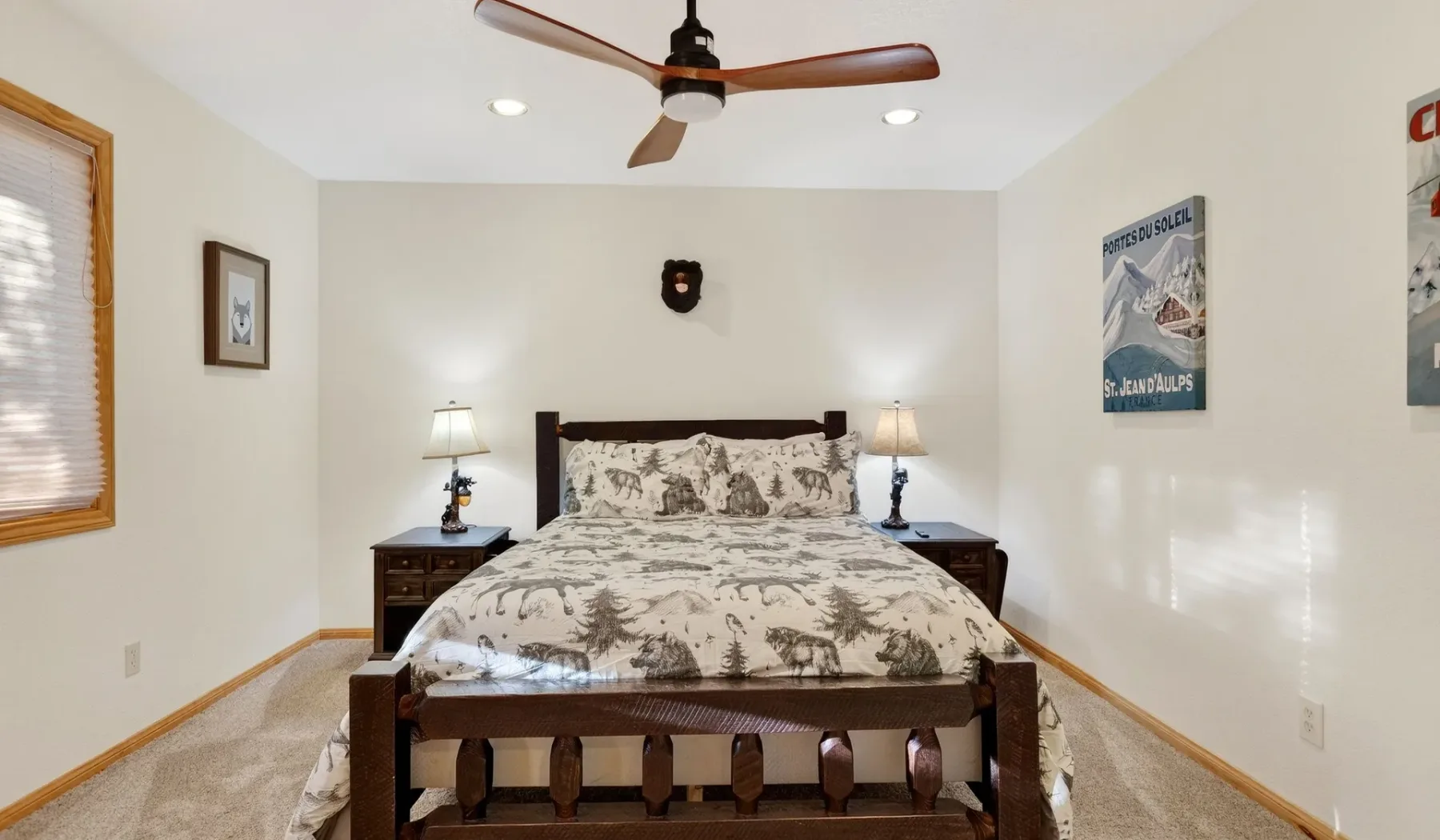 A bedroom with a bed, matching bedside tables, and a ceiling fan.