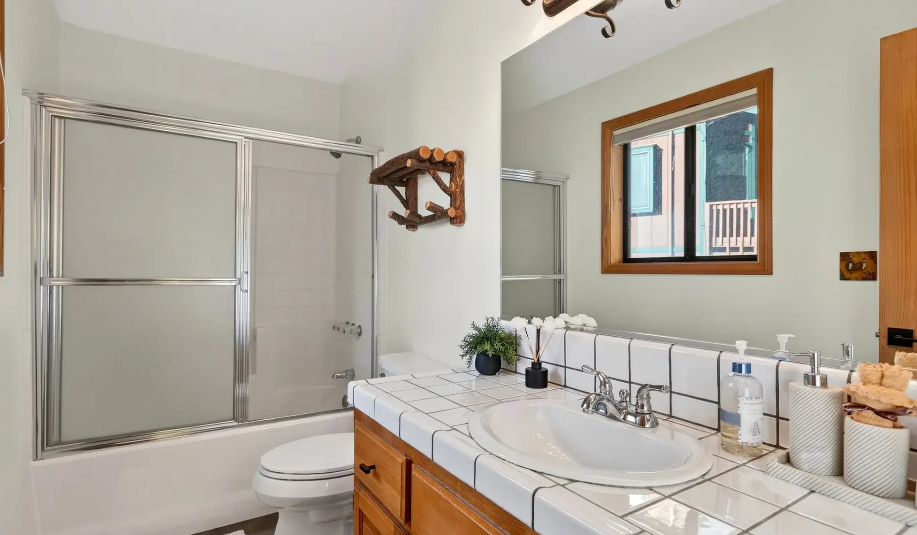 A bathroom with a tiled vanity, sink, and bathtub.