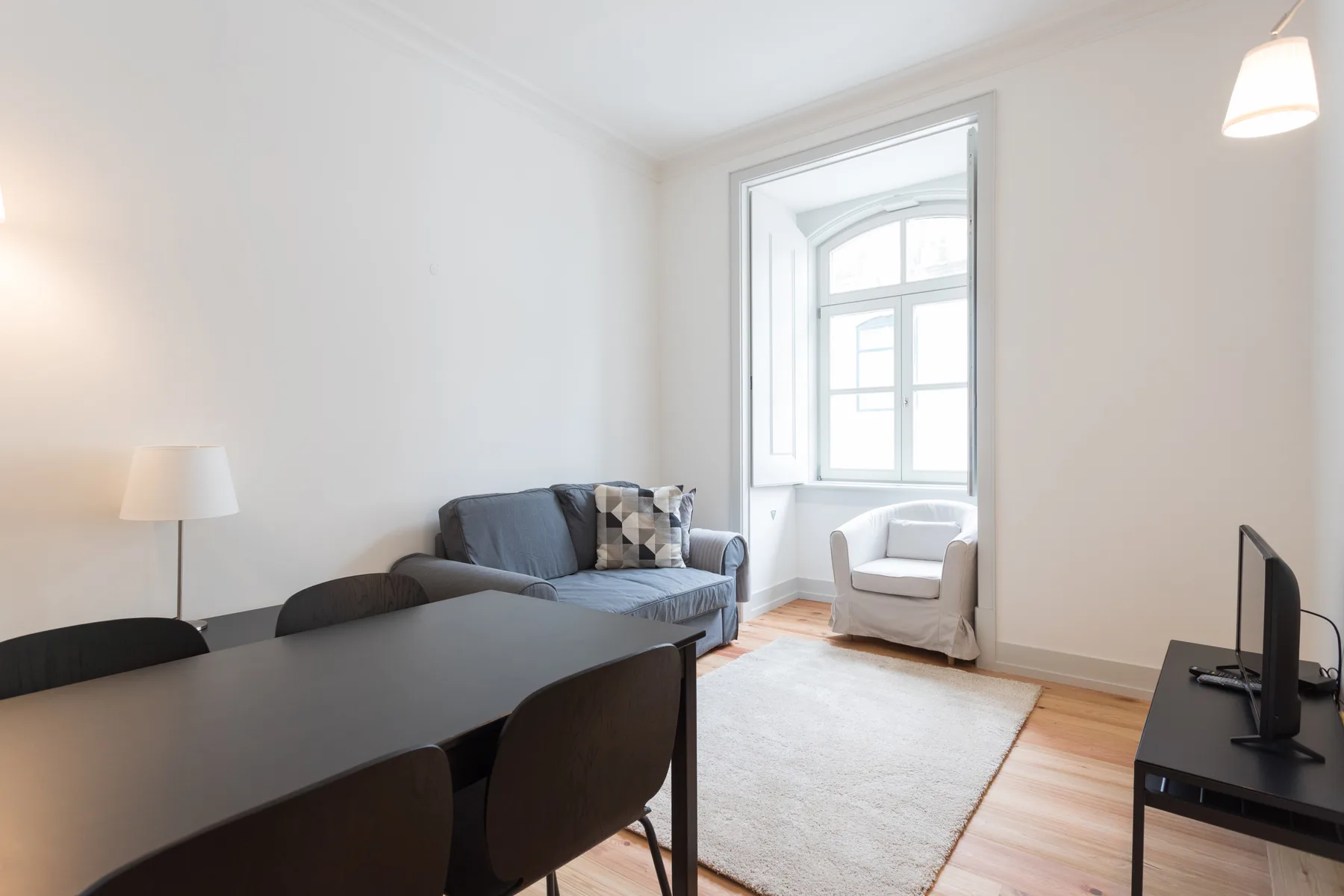 A living and dining area with seating beside a bright window.