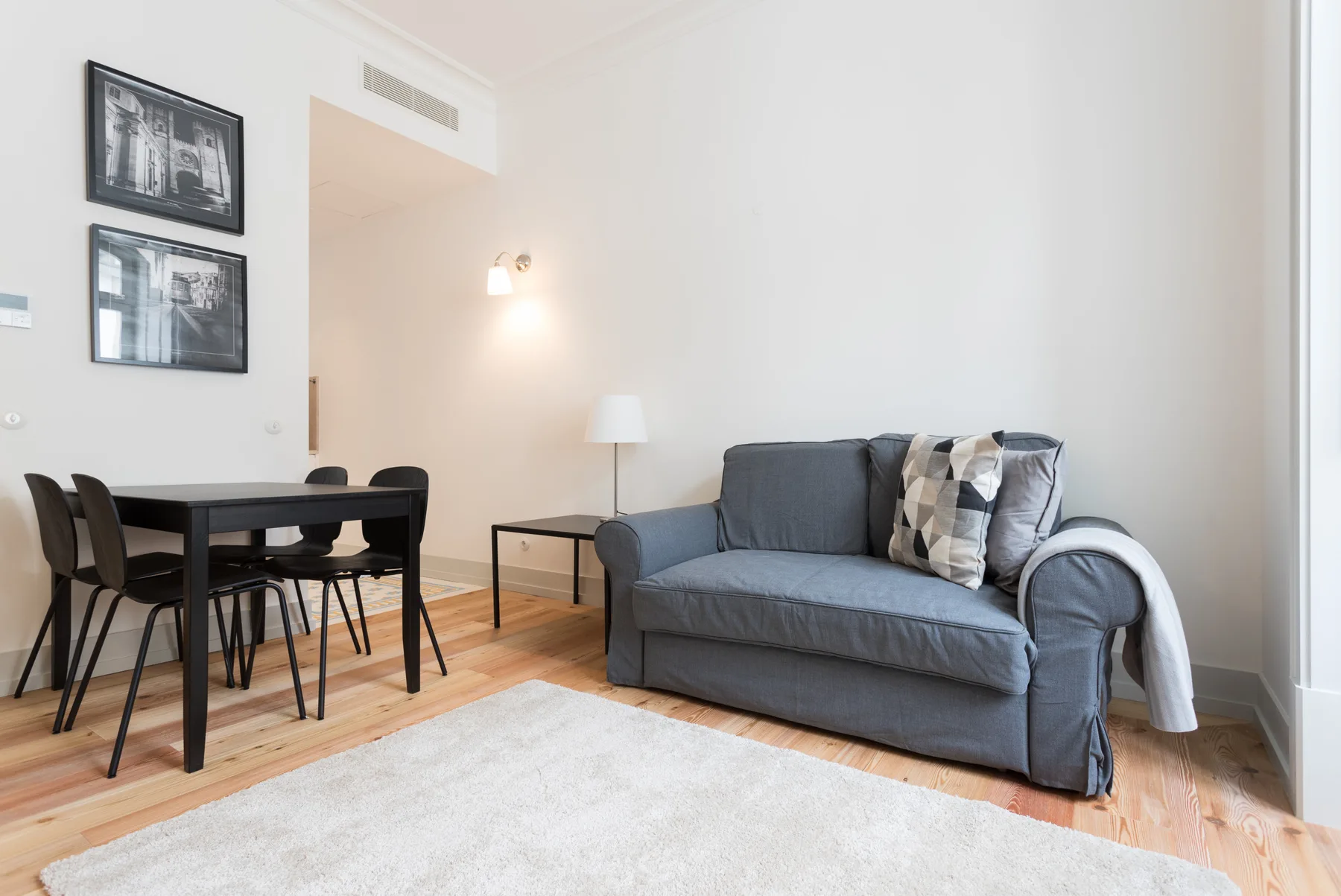 Living room with a gray sofa and dining table.