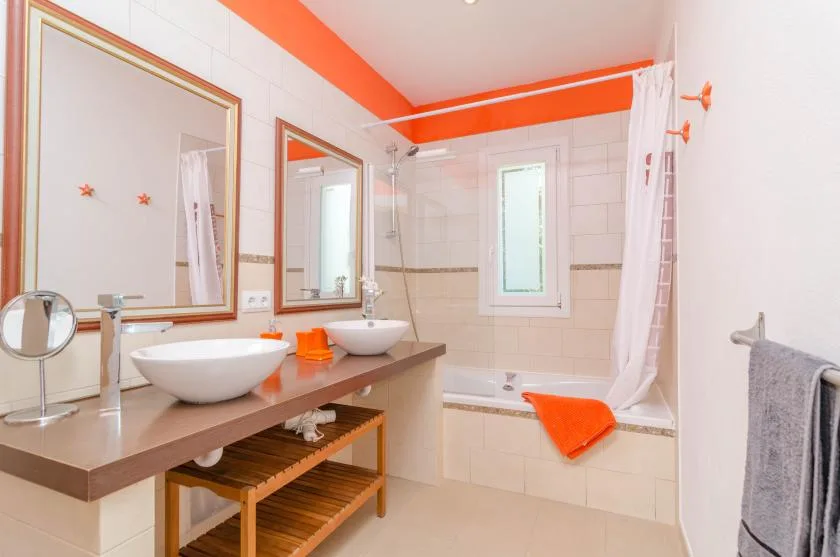 A bathroom with a double sink vanity and a bathtub behind a shower curtain.