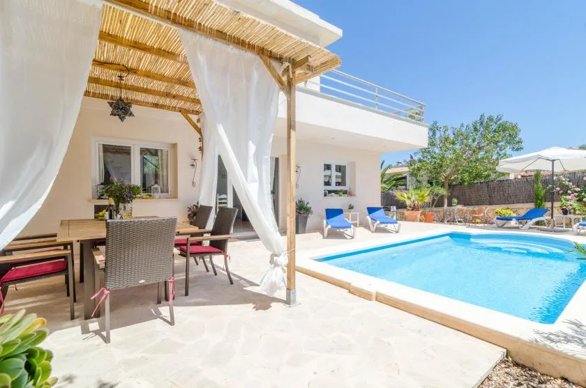 A sunny patio with a swimming pool and shaded outdoor seating.
