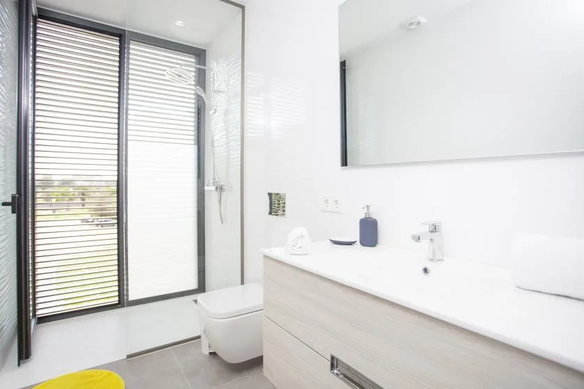 Un baño luminoso con un amplio lavabo y un espejo grande.