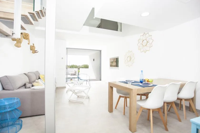 Una luminosa sala de estar y comedor de concepto abierto con mesa y asientos.