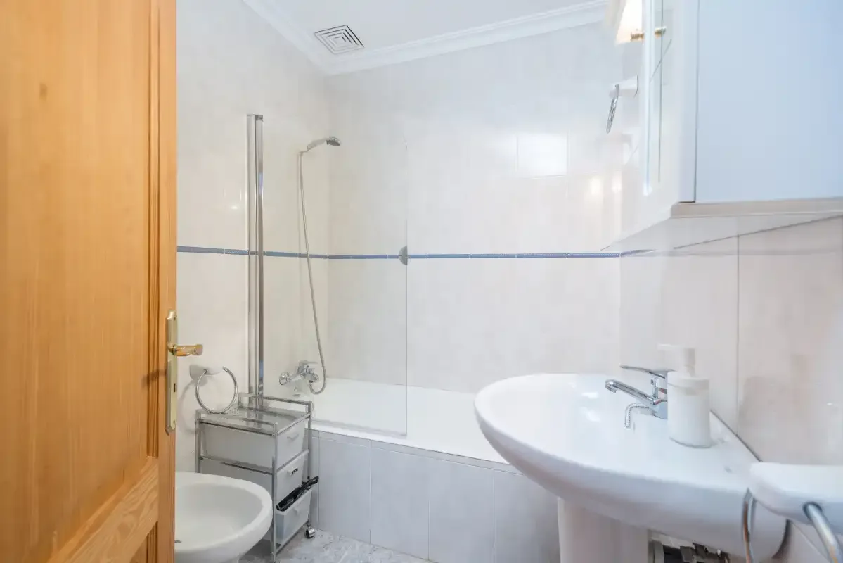 A bathroom with a bathtub, shower, and sink.