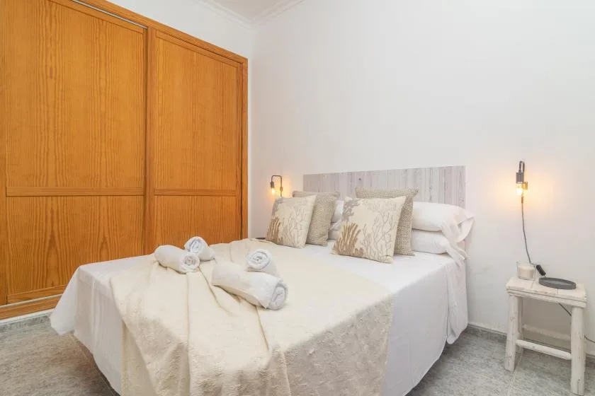 A bedroom with a neatly made bed and wooden sliding doors.