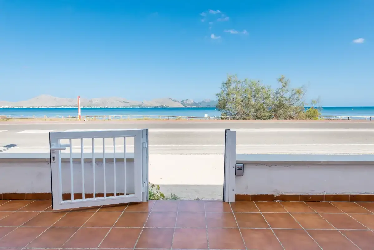 A tiled terrace overlooks a sandy beach and the sea.