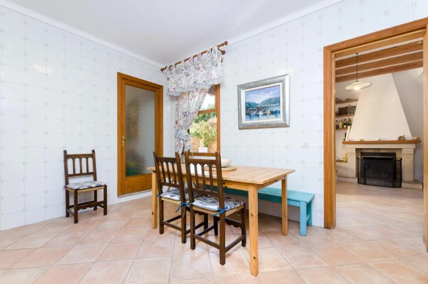 A dining area with a wooden table, chairs, and a turquoise bench.