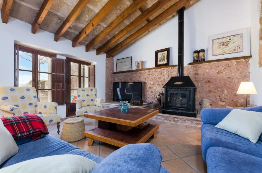 A living room with blue seating, a wooden coffee table, and a fireplace.