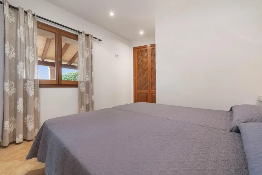 Un dormitorio con una cama grande, una ventana con cortinas y una puerta de madera.