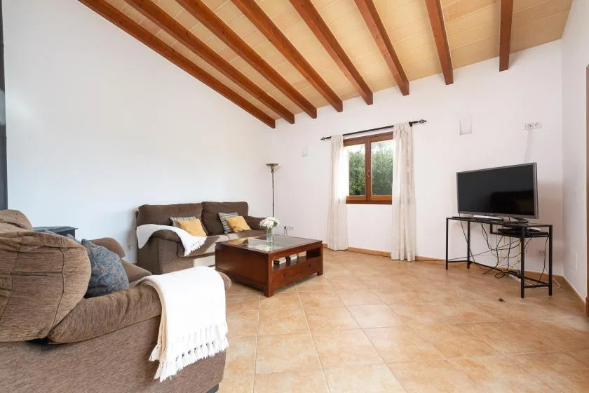 Una sala de estar con asientos, una mesa de centro y un televisor.