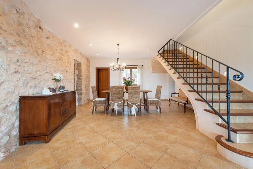 Un comedor con una mesa y sillas junto a una escalera.