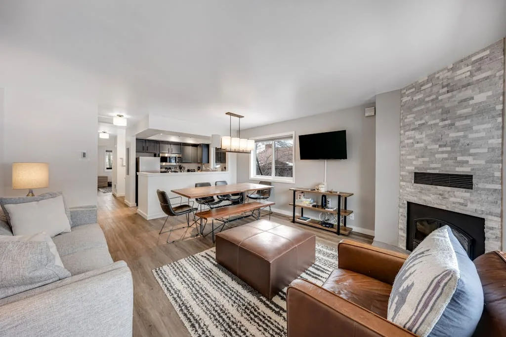 An open-plan living and dining area with seating, a dining table, and a fireplace.