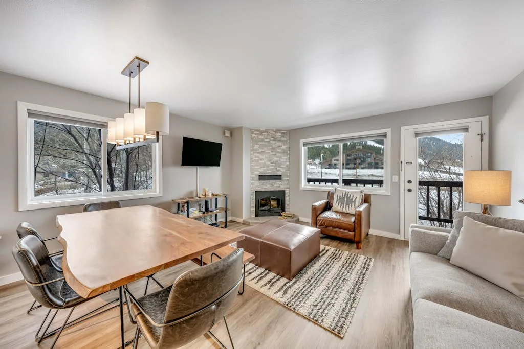 A living and dining area with seating, a table, and a fireplace.