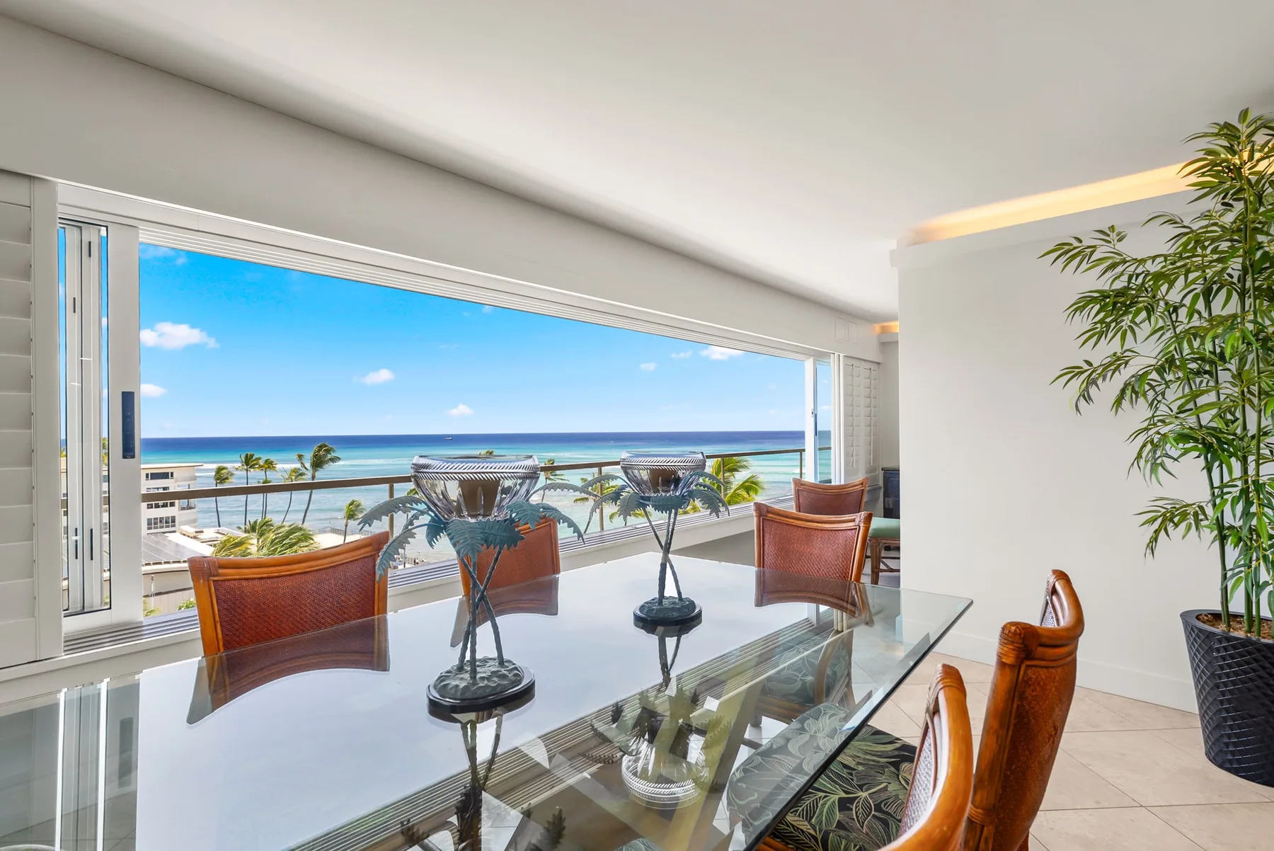 Una luminosa sala se abre a un balcón con asientos y vistas al mar.